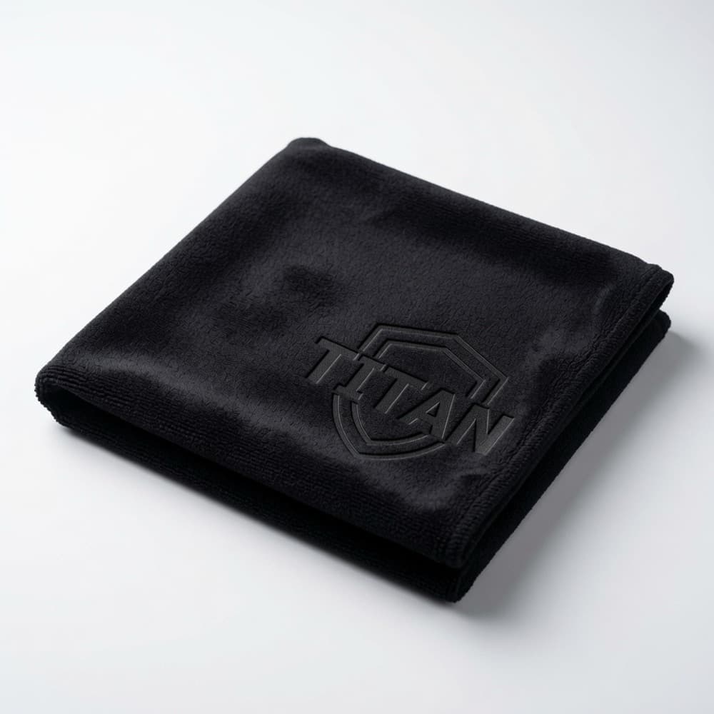 Folded black microfiber towel with a tone-on-tone laser-engraved sample logo